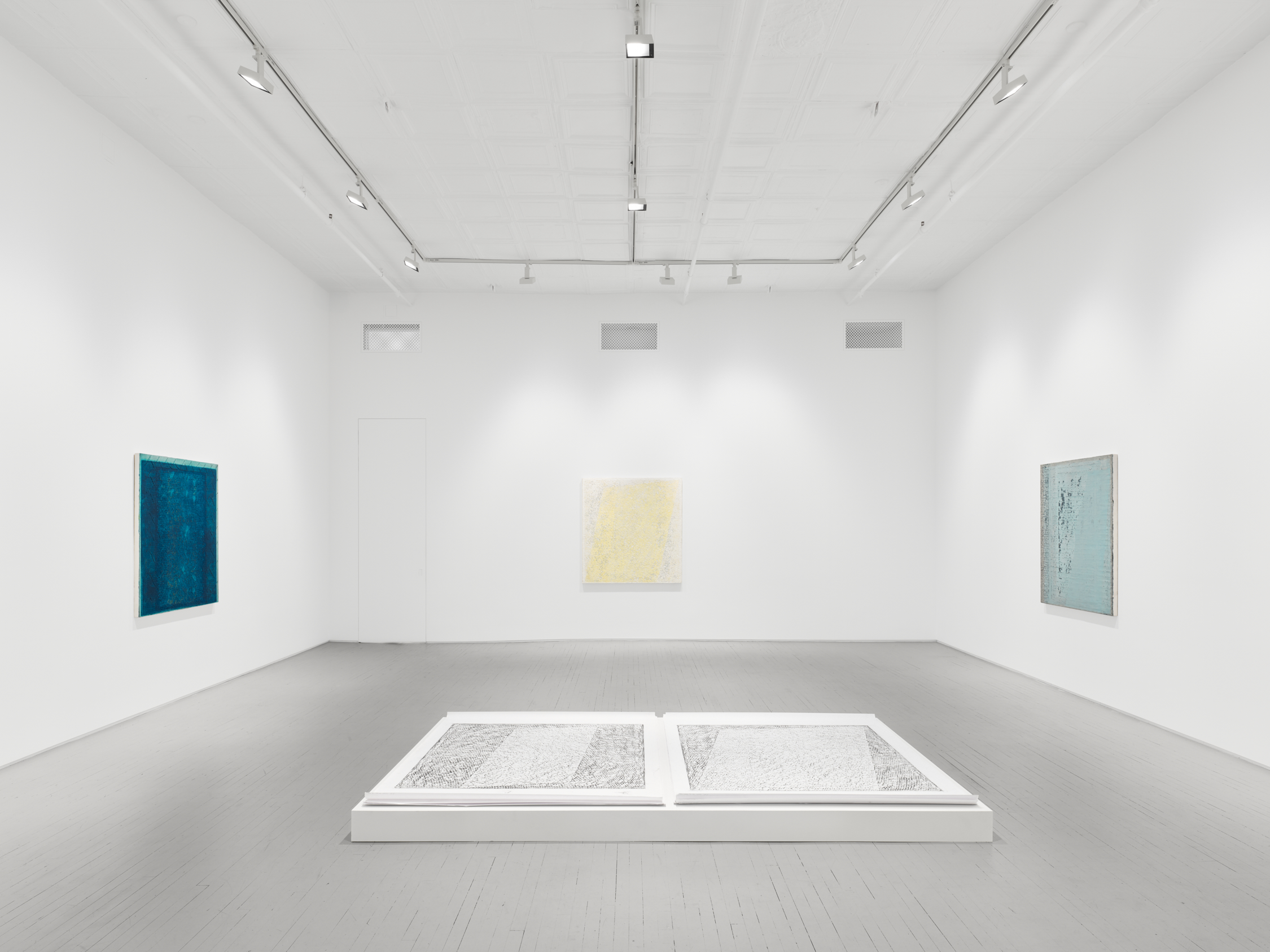 Installation image of four artworks in a white box gallery space