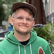 Nick Sherman white male with glasses wearing green sweatshirt