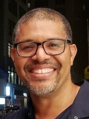 Headshot of a person wearing glasses smiling at the camera