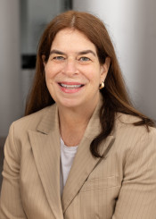 Headshot of woman in beige pinstripe jacket