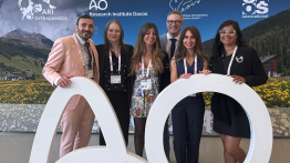 6 people stand by a sign that says AO