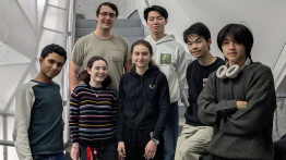 Seven students stand in a group