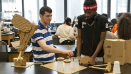 Students in the Rube Goldberg class prototype  components with cardboard and cups before 3D printing final parts.