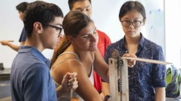Summer STEM students test a gear for an elevator in the Rube Goldberg machine.