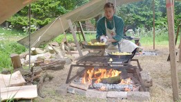 Angus tends the fire under the tents