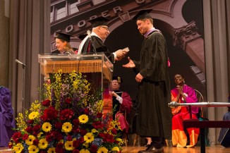 Dean Willam Germano hands a Merit Award in Architecture to Max Dowd. The co-recipient, Alice Colverd, is at left