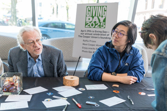 Cooper Union staff greet visitors at a Giving Day table.